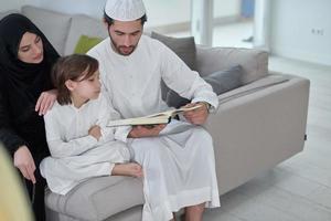 jong moslim familie lezing koran gedurende Ramadan foto