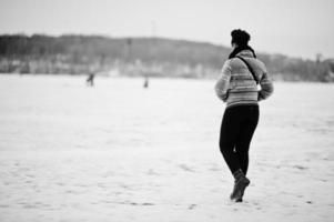 terug van Afrikaanse vrouw slijtage in zwart sjaal houding in winter dag Bij Europa. foto