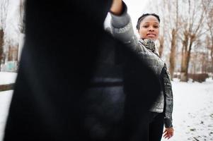 Afrikaanse vrouw slijtage in zwart sjaal houding in winter dag Bij Europa. foto