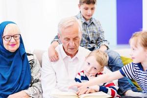 modern moslim grootouders met kleinkinderen lezing koran foto