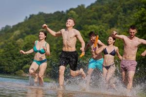 groep van gelukkig vrienden hebben pret Aan rivier- foto