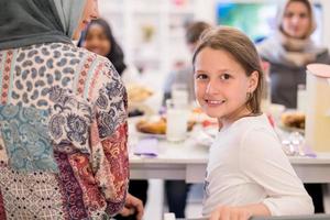 schattig weinig meisje genieten van iftar avondeten met familie foto