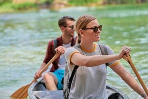 vrienden zijn kanoën in een wild rivier- foto