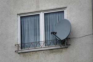 venster in huis muur met satelliet antenne foto