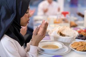 modern zwart moslim vrouw bidden voordat hebben iftar avondeten foto