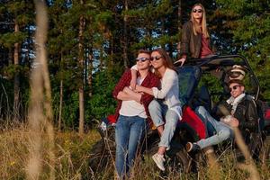 groep jong gelukkig mensen genieten van mooi zonnig dag terwijl het rijden een uit weg buggy auto foto