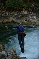 Mens jumping in wild rivier- foto