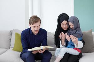 moslim familie lezing koran en bidden Bij huis foto