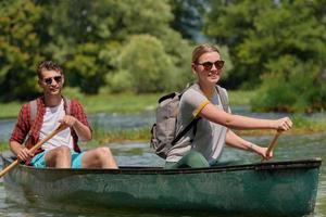 vrienden zijn kanoën in een wild rivier- foto