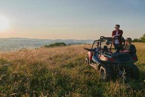 groep jong gelukkig mensen genieten van mooi zonnig dag terwijl het rijden een uit weg buggy auto foto