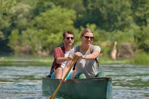 vrienden zijn kanoën in een wild rivier- foto