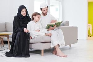 moslim familie lezing koran en bidden Bij huis foto