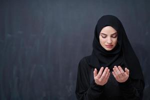moslim vrouw maken traditioneel gebed naar god in voorkant van zwart schoolbord foto
