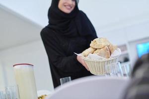 jong moslim vrouw portie voedsel voor iftar gedurende Ramadan foto