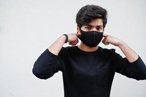 Aziatisch Mens slijtage allemaal zwart met gezicht masker geïsoleerd Aan wit achtergrond. foto