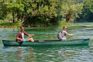 vrienden zijn kanoën in een wild rivier- foto