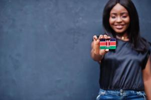Afrikaanse vrouw houden klein Kenia vlag in handen. foto