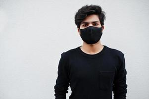 Aziatisch Mens slijtage allemaal zwart met gezicht masker geïsoleerd Aan wit achtergrond. foto