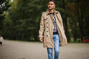 elegant Koeweit Mens Bij loopgraaf jas wandelen Bij park. foto