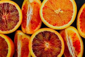 top visie van vers bloed oranje helften en kwarten. fruit achtergrond. foto