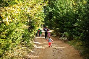 moeder met vier kinderen resting in bergen. familie reizen en wandelen met kinderen. terug van rennen baby meisje. foto