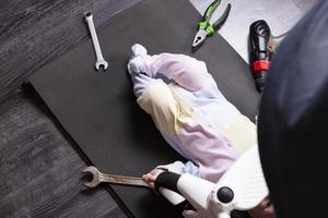 jongen monteur reparaties de suspensie van een baby koets. wij reparatie alles dat reizen. humor foto