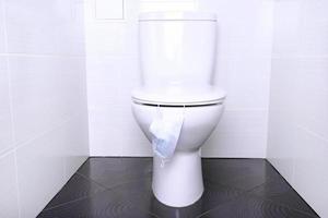 wit huis toilet met doorspoelen en beschikbaar medisch masker in de badkamer. quarantaine concept. foto