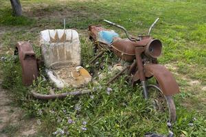 een oud, roestig motorfiets met een zijspan staat Aan een groen gras. foto