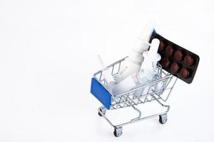 verscheidenheid van pillen in blaar pakketten in een mini boodschappen doen trolley Aan een wit achtergrond. Gezondheid en geneeskunde concept. concept van online boodschappen doen in een apotheek. kopiëren ruimte. foto