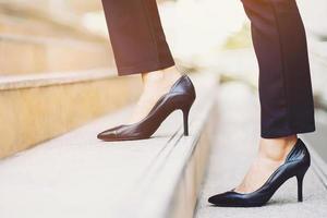 moderne zakenvrouw werkende vrouw close-up benen lopen de trap op in de moderne stad in de spits om haast te werken op kantoor. tijdens de eerste werkdag. laat ruimte voor het schrijven van beschrijvende tekst foto