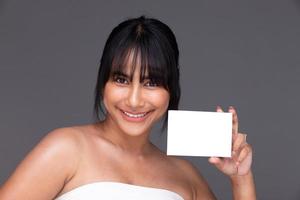 Aziatisch Indisch vrouw tonen mooi glimlach gelukkig lippen, houden leeg blanco pakket doos voor behandeling huid foto