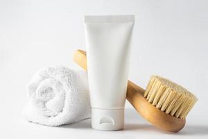 spa cosmetica, vrouw lichaam en huidsverzorging producten Aan wit achtergrond. natuurlijk varkenshaar droog massage borstel en lichaam of gezicht room in wit plastic buis. foto