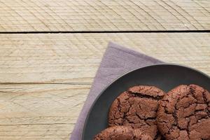 top visie van eigengemaakt chocoladetaart koekjes Aan zwart bord Aan houten achtergrond. huis bakkerij foto