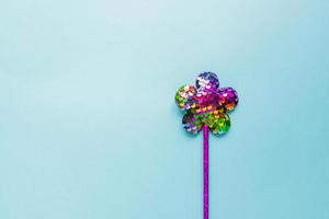 magie stok van pailletten in bloem vorm Aan pastel blauw achtergrond. creatief vlak leggen in minimaal stijl foto