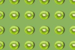 patroon van kiwi fruit Aan groen achtergrond, vergelijkbaar plakjes. foto