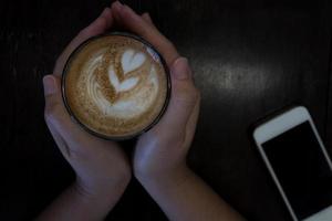 vrouw Holding heet kop van latte koffie foto