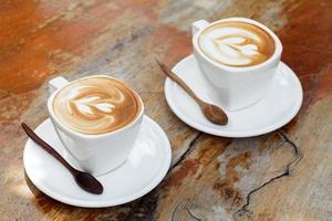 kop van latte koffie Aan houten tafel foto