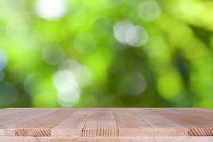 houten tafelblad op bokeh groene achtergrond - kan worden gebruikt voor montage of om uw producten weer te geven foto