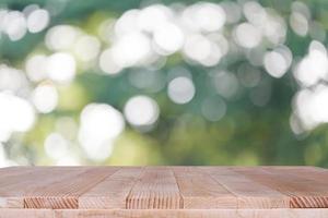 houten tafelblad op bokeh groene achtergrond - kan worden gebruikt voor montage of om uw producten weer te geven foto