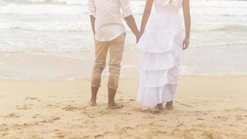 gelukkig jong paar vervelend wit jurk Aan de strand Aan vakantie, reis, romantisch, bruiloft concept foto