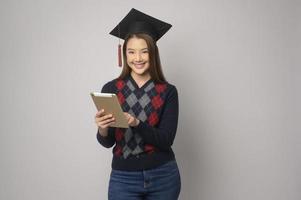 jong glimlachen vrouw Holding diploma uitreiking hoed, onderwijs en Universiteit concept foto