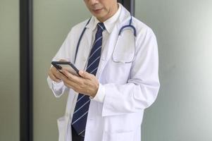 portret van zelfverzekerd glimlachen dokter vervelend wit jas in ziekenhuis foto