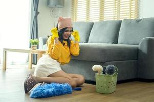 jong uitgeput en moe huishoudster vervelend geel overhemd in leven kamer. foto