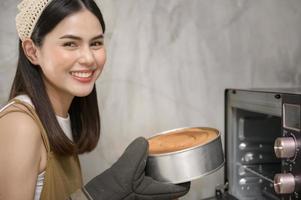 jonge mooie vrouw bakt in haar keuken, bakkerij en coffeeshopbedrijf foto