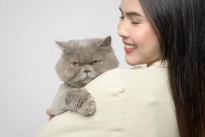 een jong vrouw is Holding lief kat , spelen met kat in studio Aan wit achtergrond foto