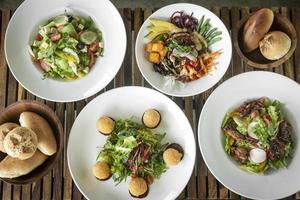 meerdere verschillend vers salade gerechten Aan restaurant tafel foto