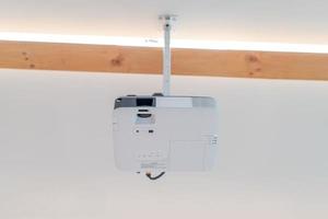 de projector wordt aan het plafond van de seminariezaal gehangen. het staat klaar om de presentatie van de spreker te verlichten. foto