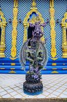 het blauw - turquiose metalen godsstandbeeld in thaise blauwe tempel, in het noorden van thailand. foto