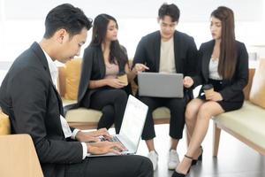 jong collega's. jong modern collega's in slim gewoontjes slijtage werken terwijl uitgeven tijd in de kantoor. bedrijf Mens Bij de kantoor met een laptop. foto