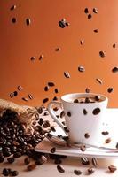 koffiebonen vallen op tafel met koffiekopje